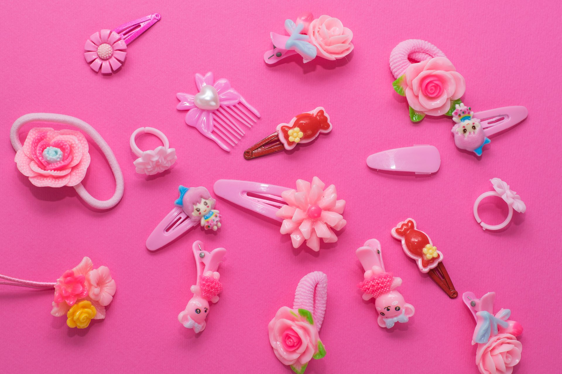 Collection of pink children's hair clips, headbands, and accessories arranged on a flat surface