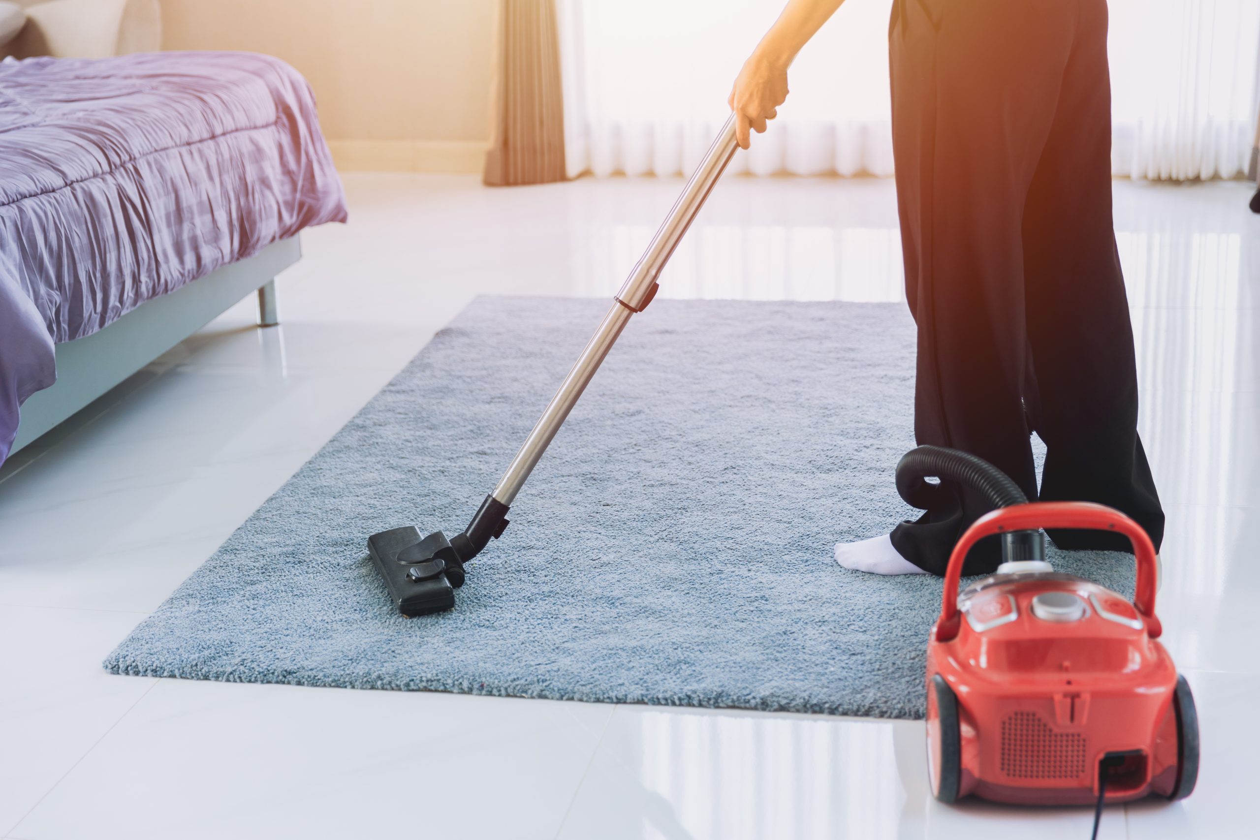 Parent vacuuming the carpet in a child's bedroom in the morning — a calm home-cleanup step after a head lice diagnosis.