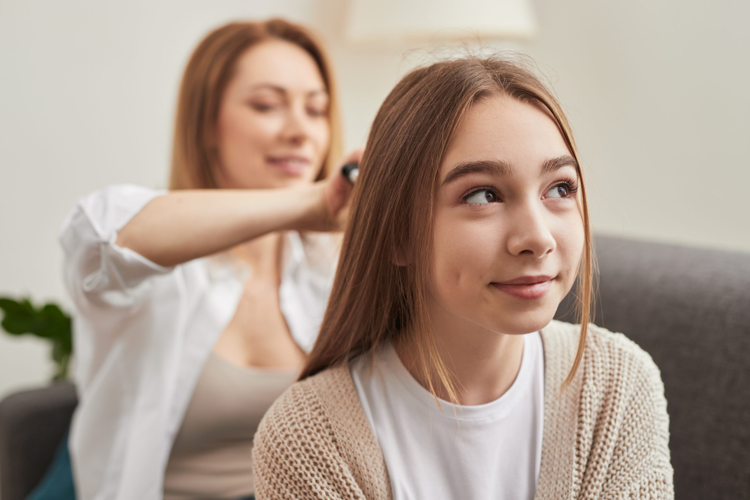 Woman Styling the Hair of a Teenager at Home